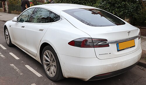 A rear three-quarters view of a white 2016 Tesla Model S