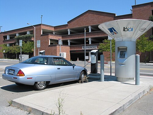 Picture of a silver car charging at a charging station in California.
