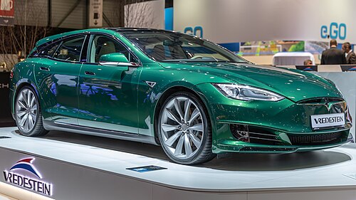 A green station wagon on display at a car show