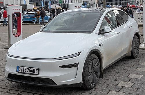 A front three-quarters view of a white 2025 facelifted Tesla Model Y